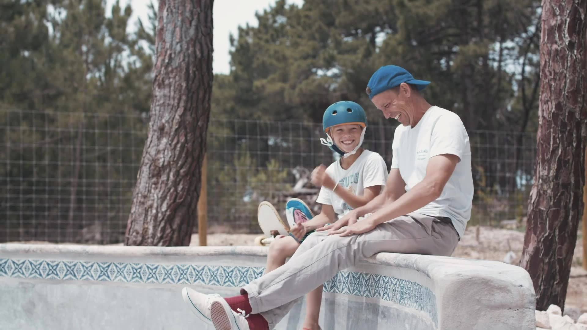 A father and son enjoy each other’s company while skateboarding, swimming, and surfing in beautiful Portuguese coastal landscapes and treehouse resorts.