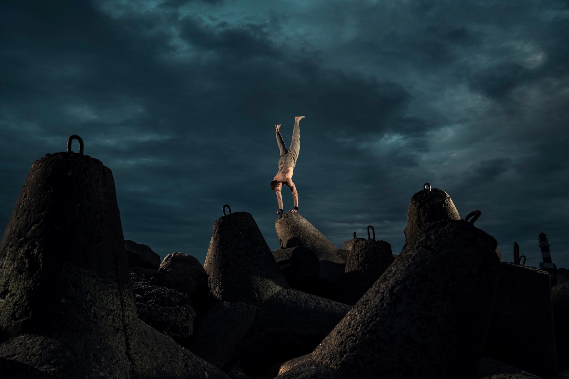 A handstanding athlete in breakwater stone blocks