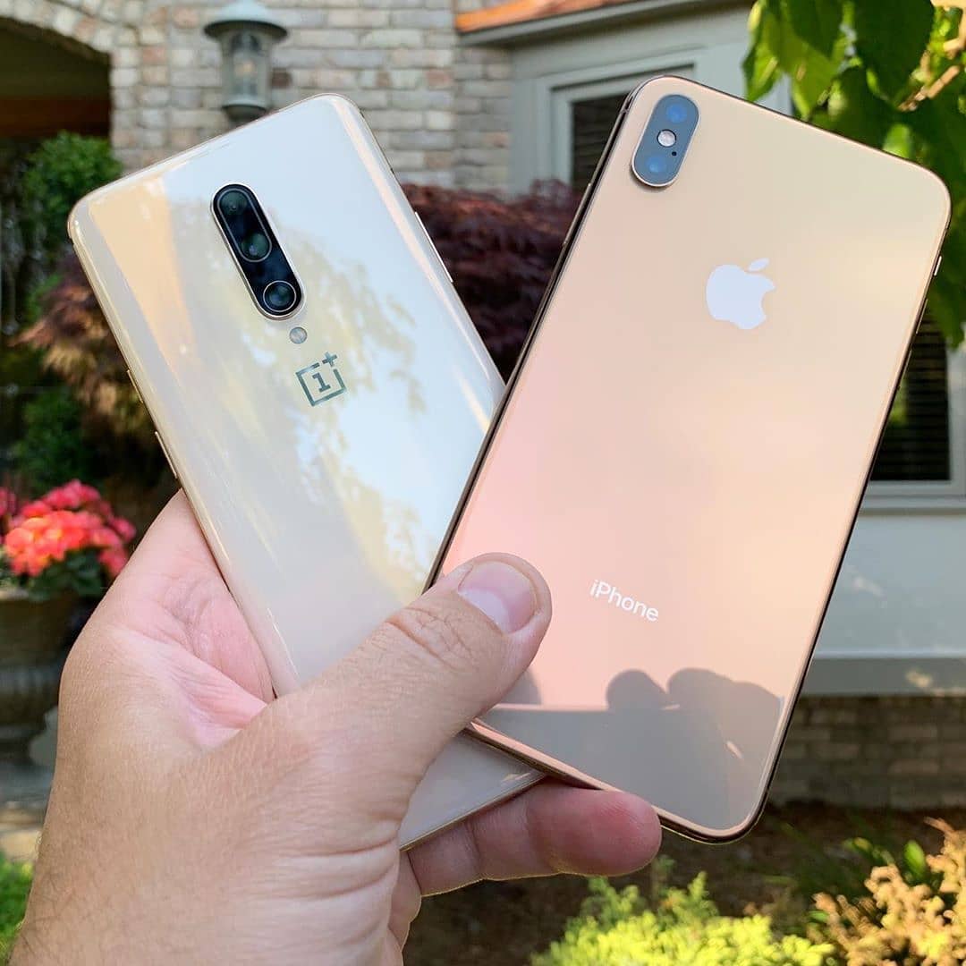 Gold comparison.  Metal is largely the same, but the iPhone glass is darker with a mirrored reflection. The OnePlus is lighter but with more special effects from the curved layered glass. Both look best in hand. #oneplus7pro @oneplus